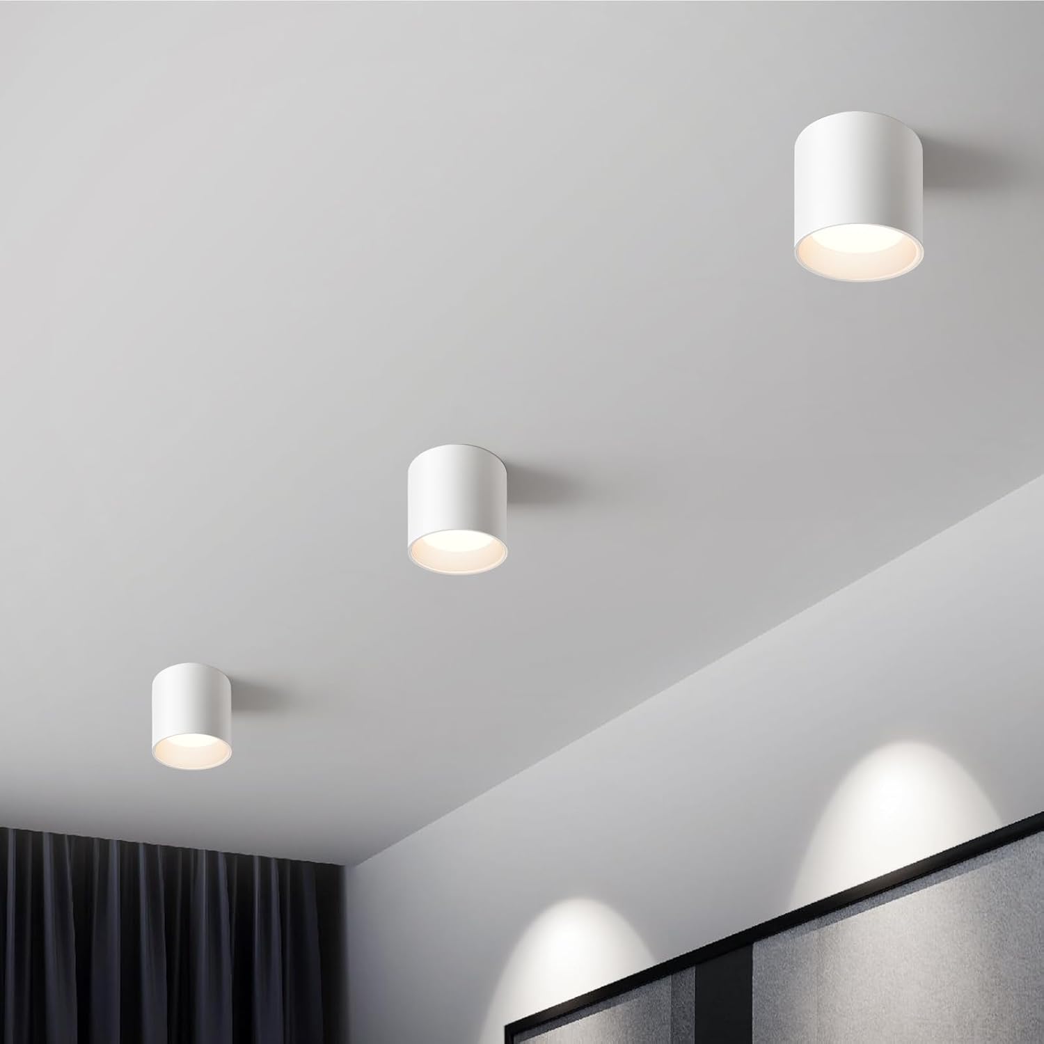 Three white ceiling lights on a gray ceiling with a modern interior setting.