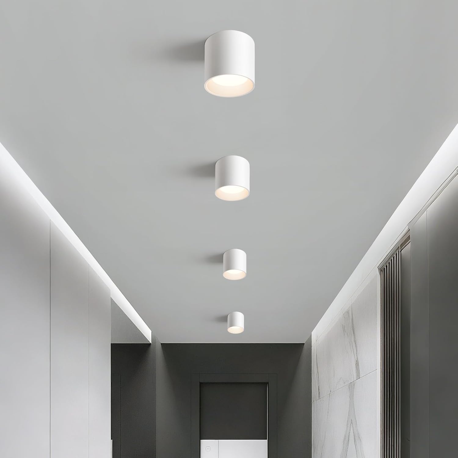 Four white ceiling lights on a gray ceiling in a modern interior setting.