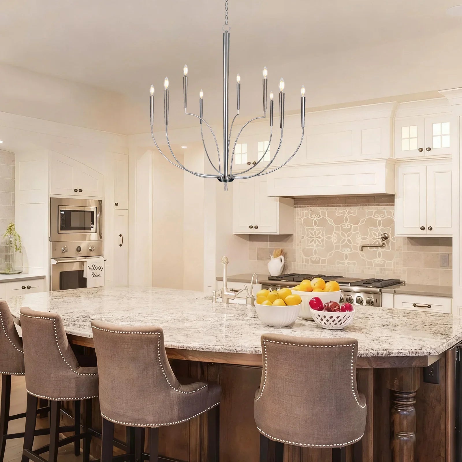Modern kitchen with marble island, chandelier, and bar stools.