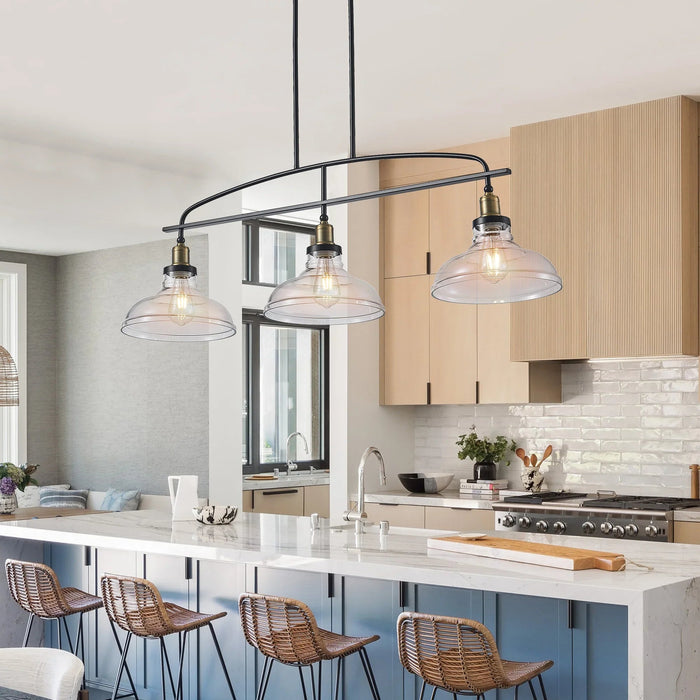 Industrial pendant chandelier with glass shades above modern kitchen island with bar stools