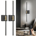 A pair of black battery operated wall sconces with gold accents.