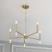 Gold chandelier with six candle-style lights on a gray ceiling.