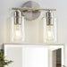 Brushed nickel bathroom vanity light fixture with two clear glass shades, mounted on a wall.