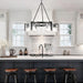 Modern kitchen with white countertops, black island, and decorative lighting fixture.